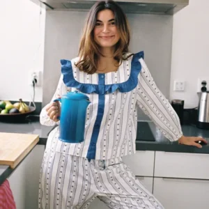 Woman wearing TBCo Cropped Cotton Pyjamas in Navy Ditsy floral holding a blue teapot in a bright kitchen setting