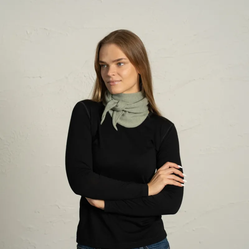 Woman wearing light green cashmere Merino wool bandana tied as neck scarf.