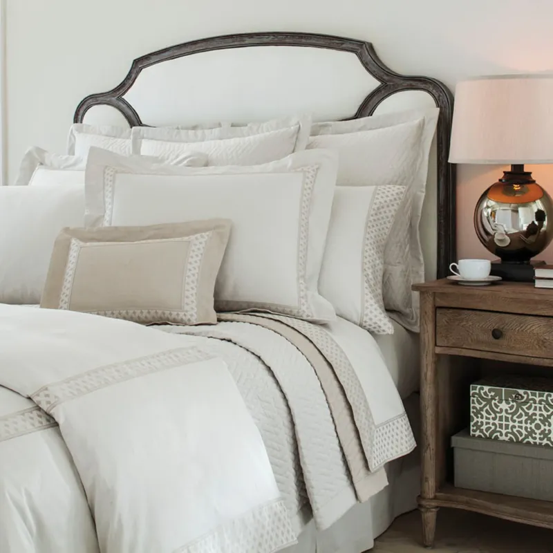 Home Treasures Ara quilted coverlet and euro shams in ivory with taupe geometric border trim.